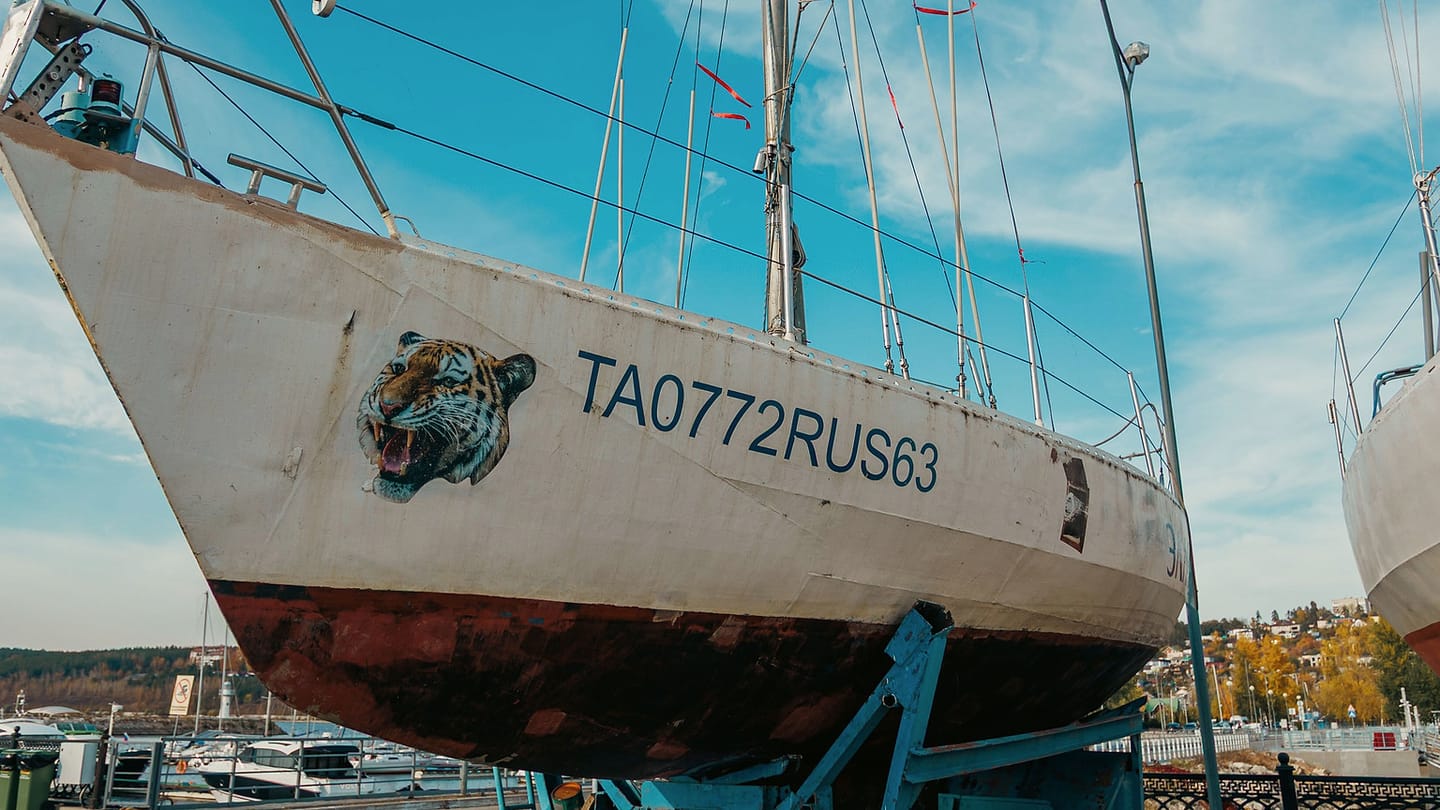 A sailboat stands ashore with its keel and underwater hull visible.