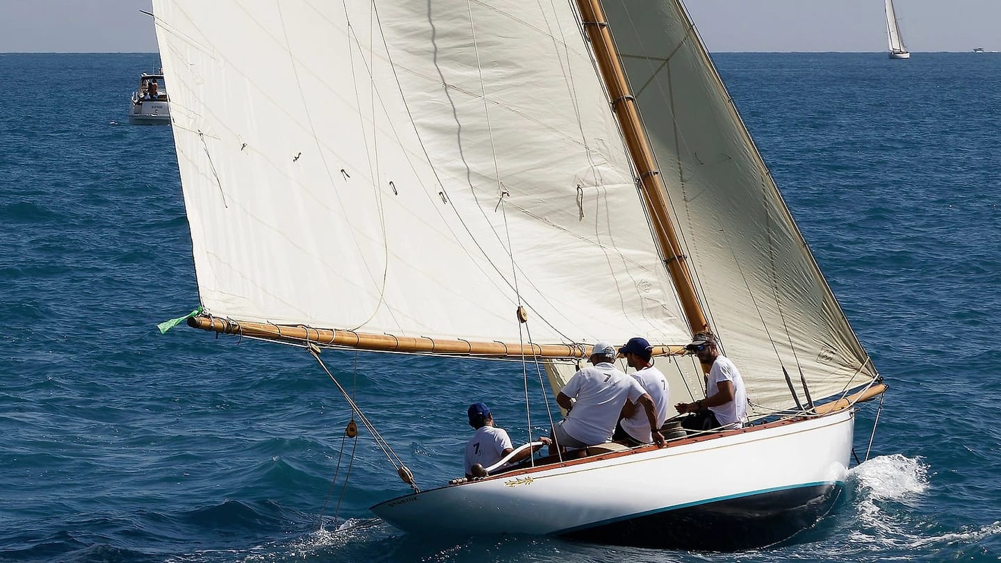 Sailboat with white sails moving through open water