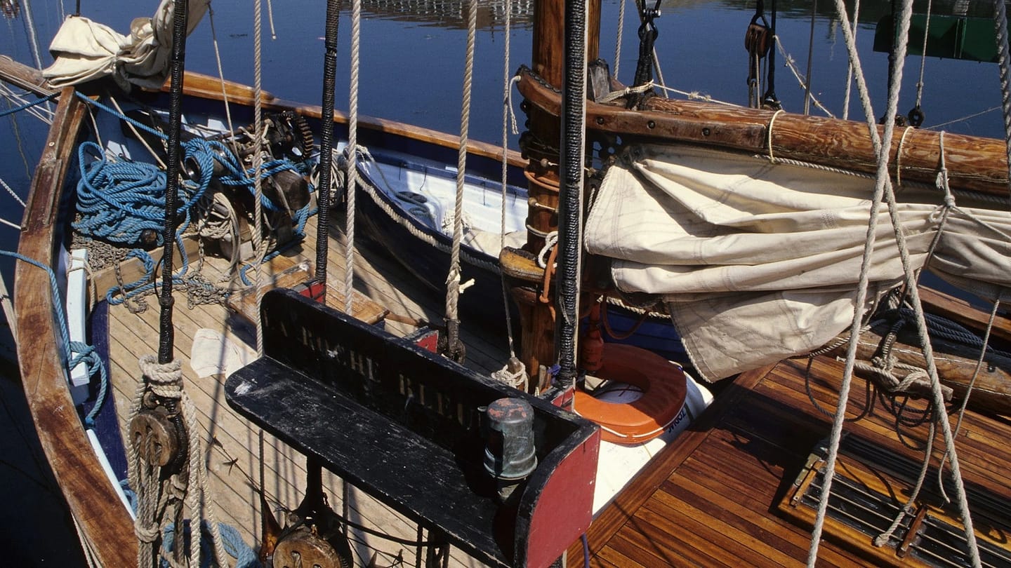 Sunlit wooden deck and rigging on a vintage boat