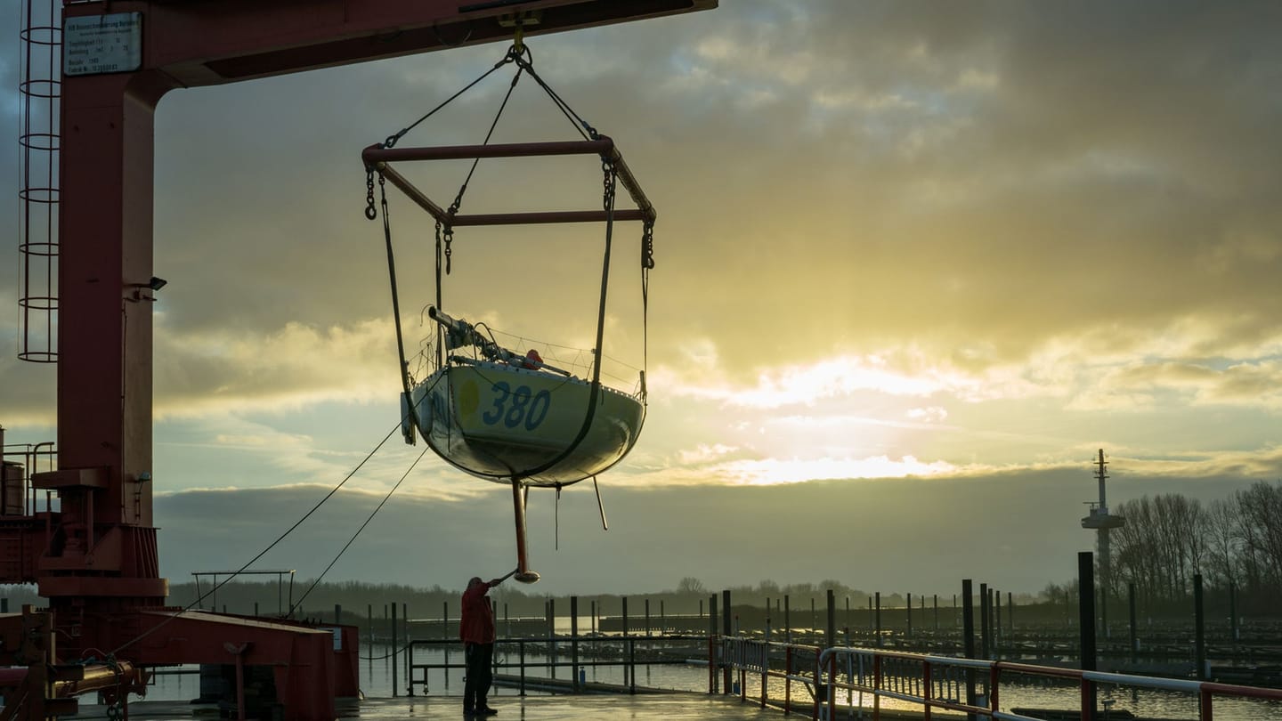 A harbour crane beside boats being prepared ashore