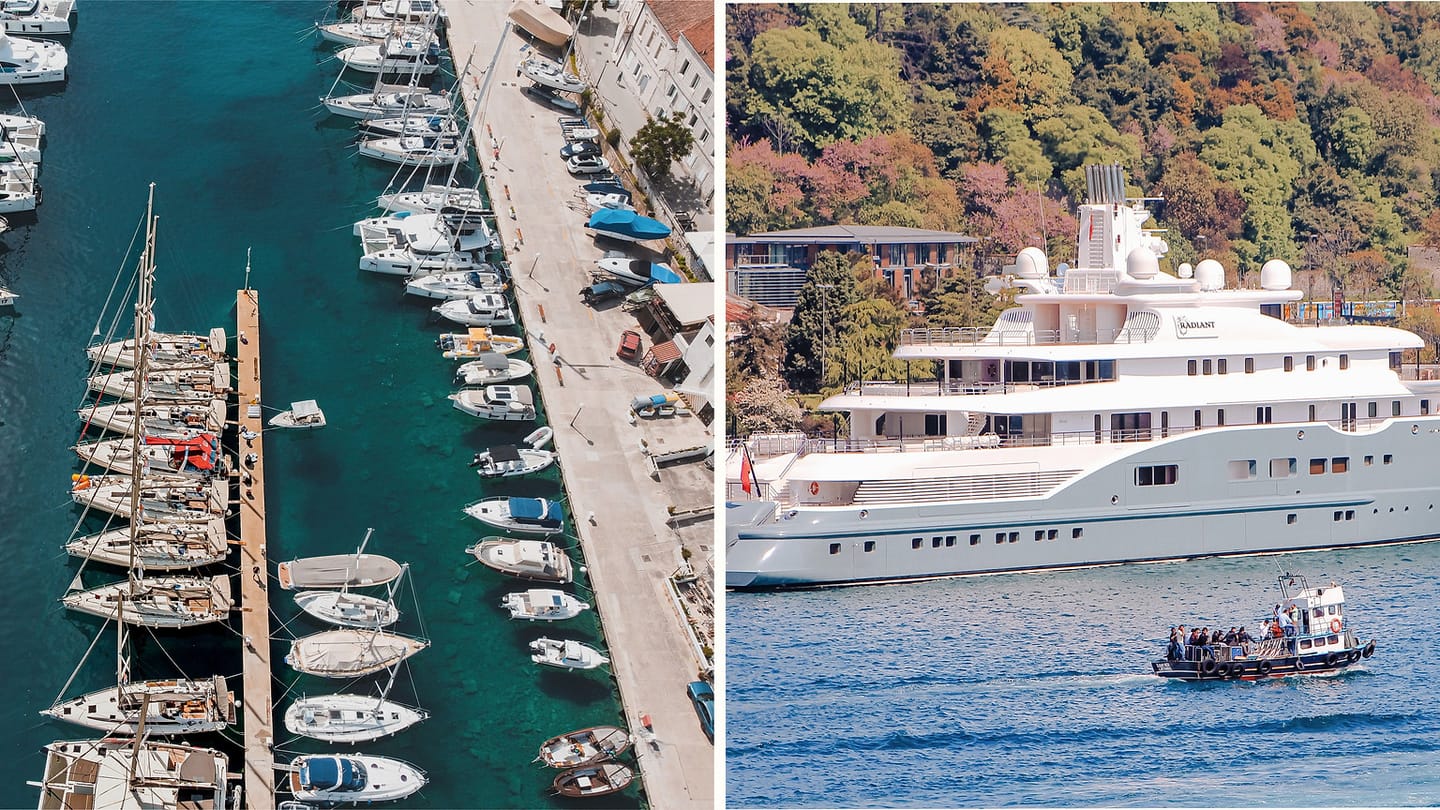 Sailboats and a large motor yacht sharing a harbour