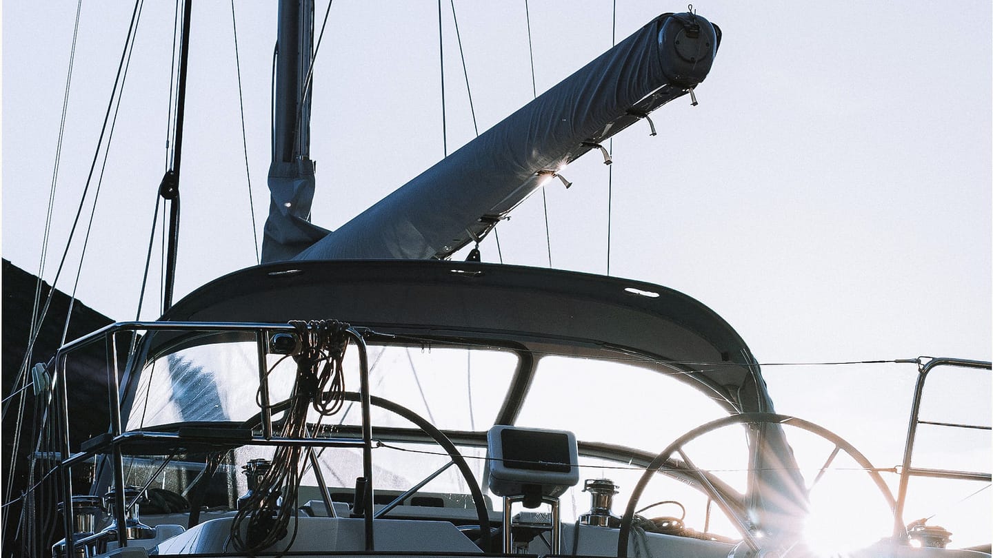 A docked sailing boat shown beside harbour craft