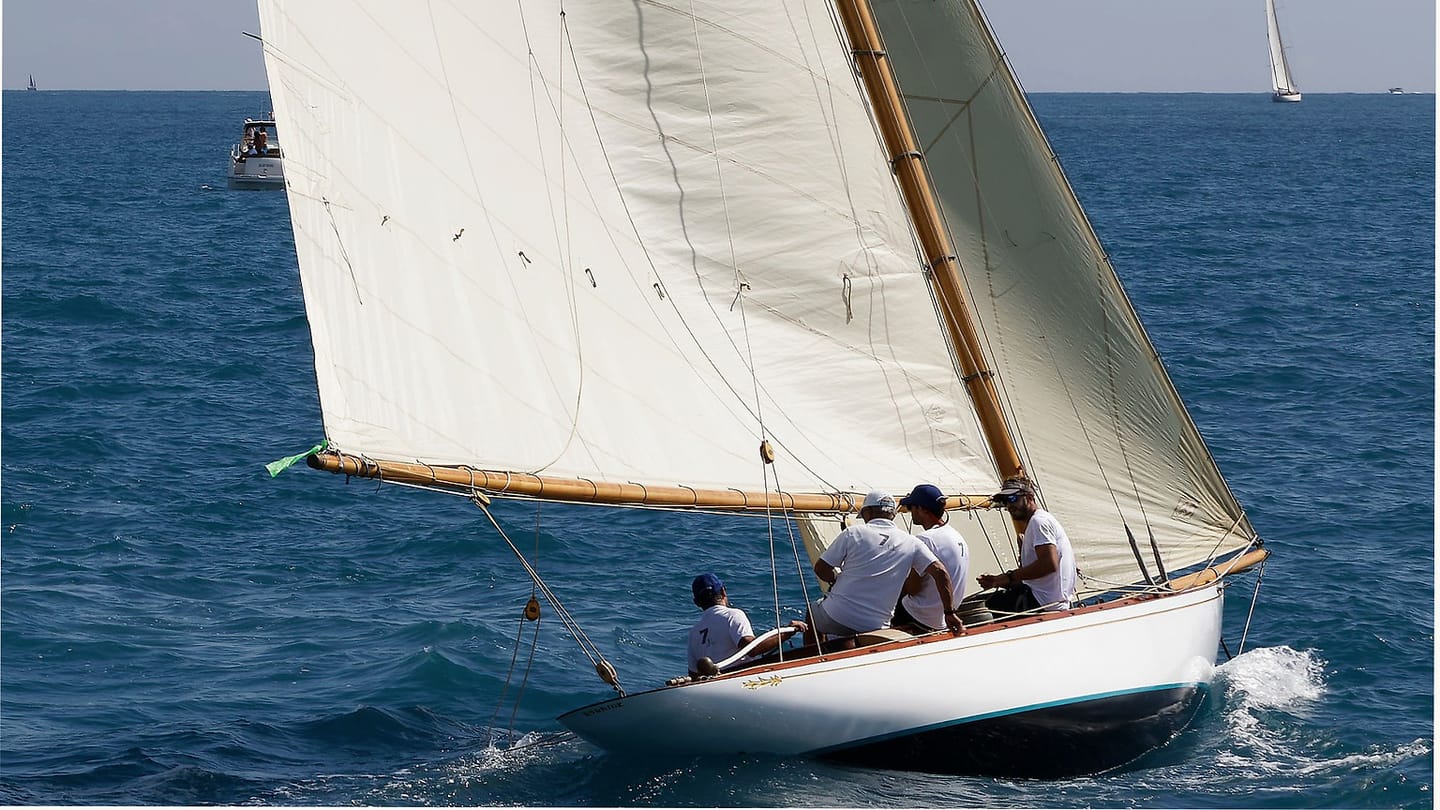 People sailing a white-hulled boat at sea