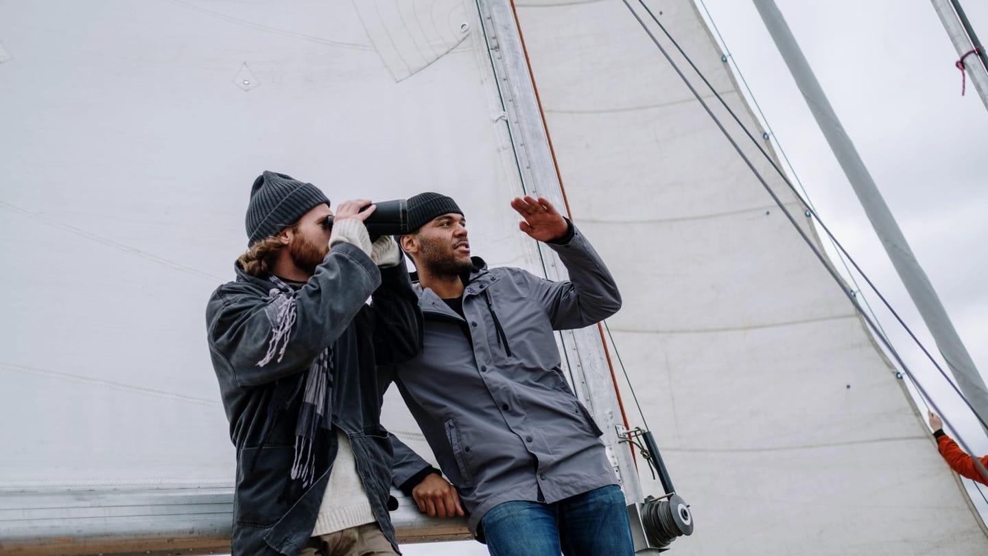 Two adults talking face to face on a sailboat deck
