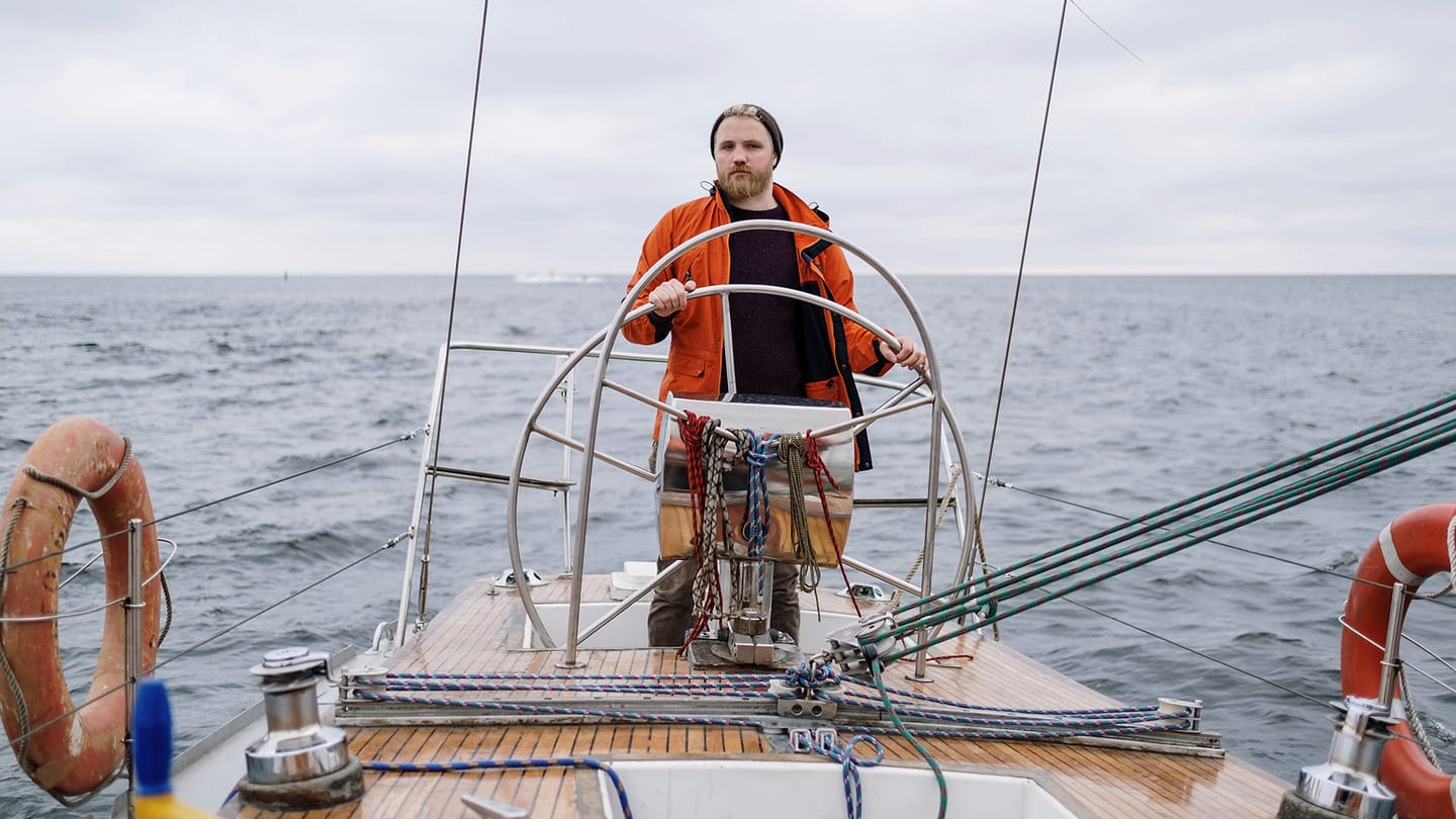 A crew member handles a line in the cockpit where movements can remain low and controlled.