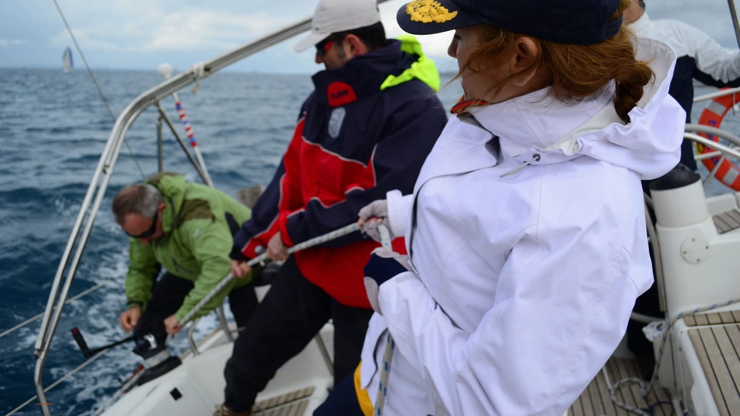 Crew members learning deck jobs aboard a sailing yacht