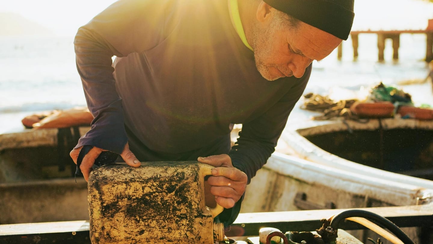 Boat mechanic working on an engine with the cover removed