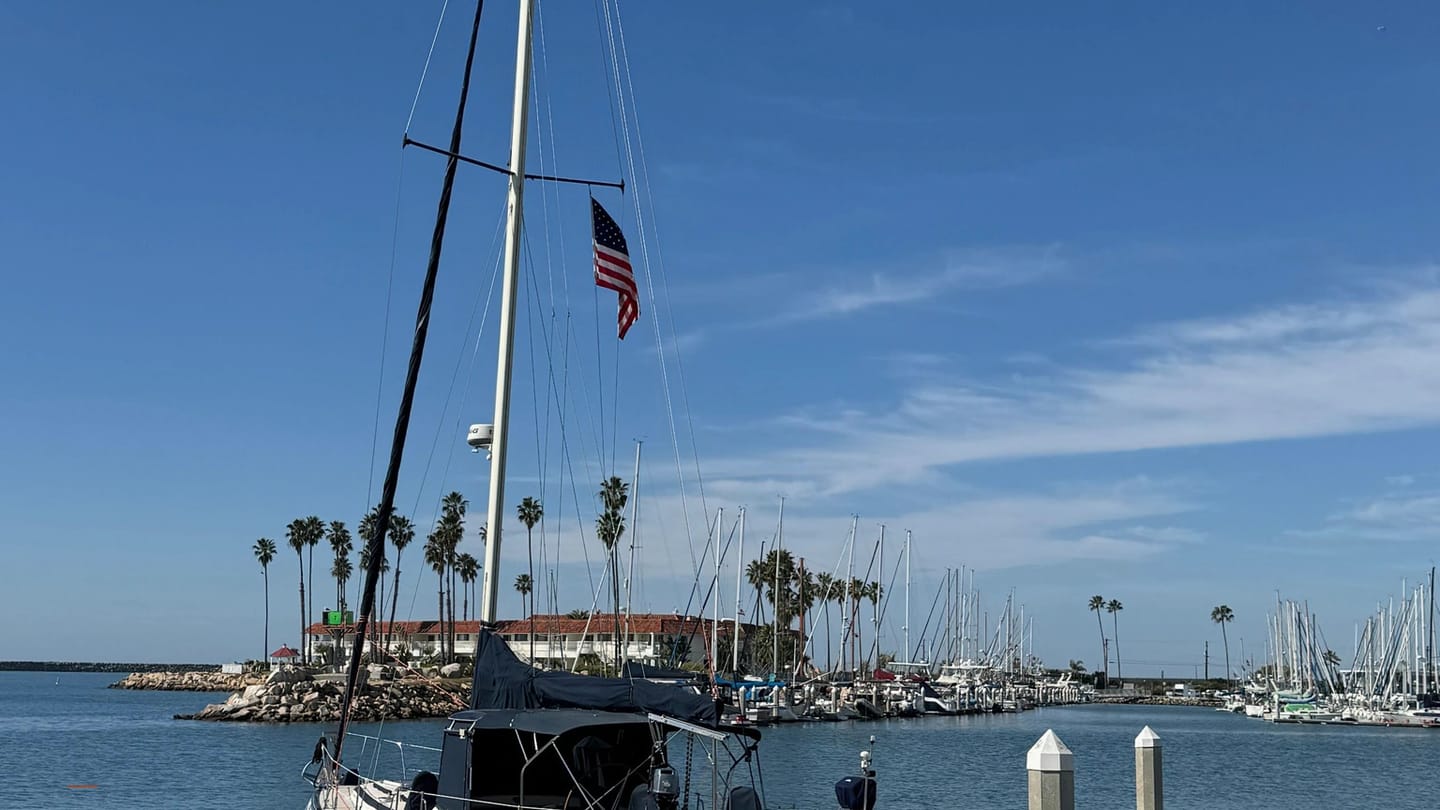 White cruising sailboat tied alongside a marina dock
