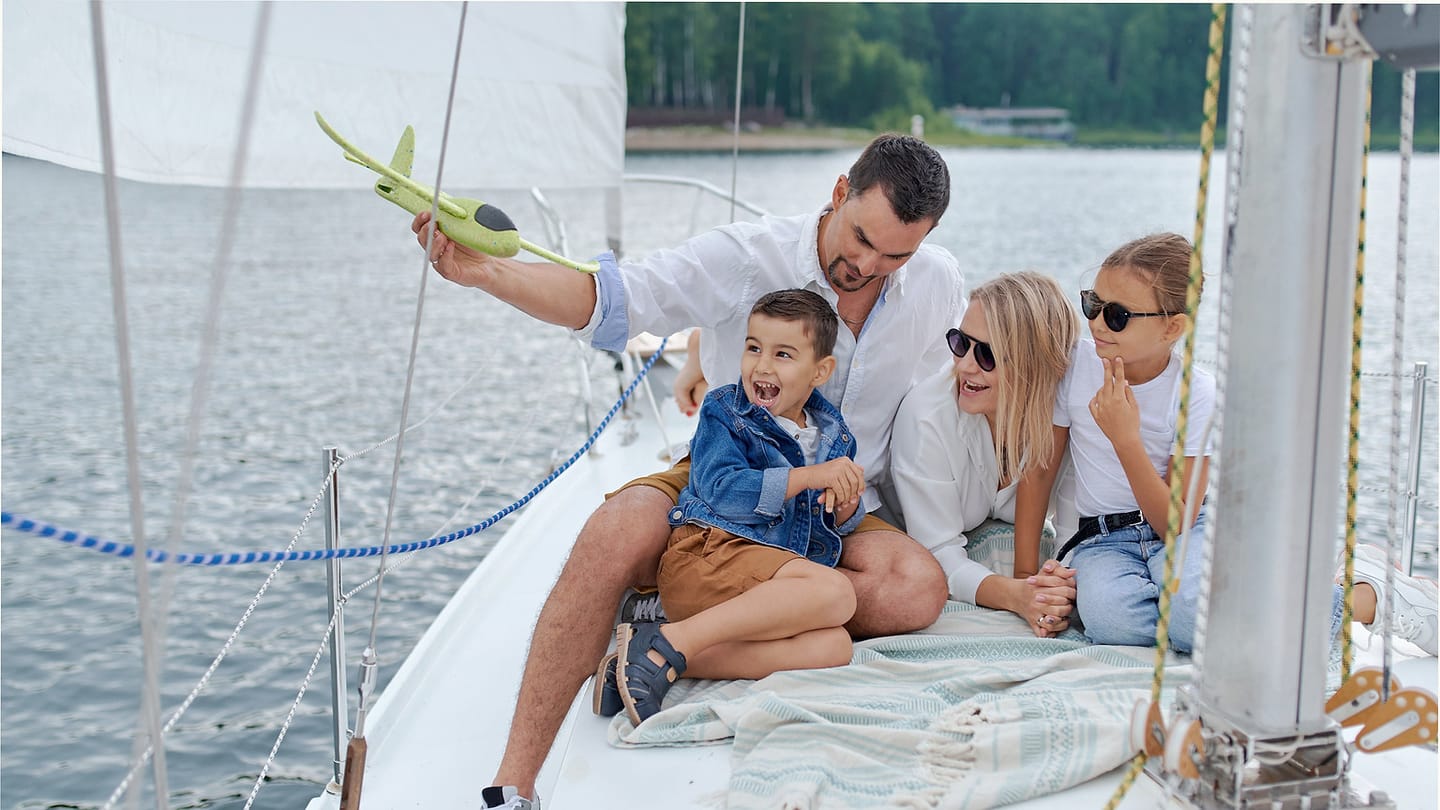 Family sitting together on a sailboat in calm water