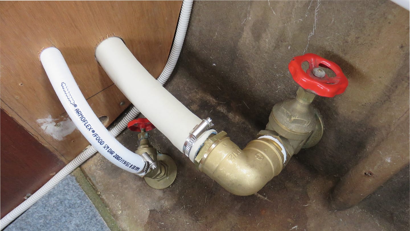 A seacock valve and its attached hose inside a pleasure craft