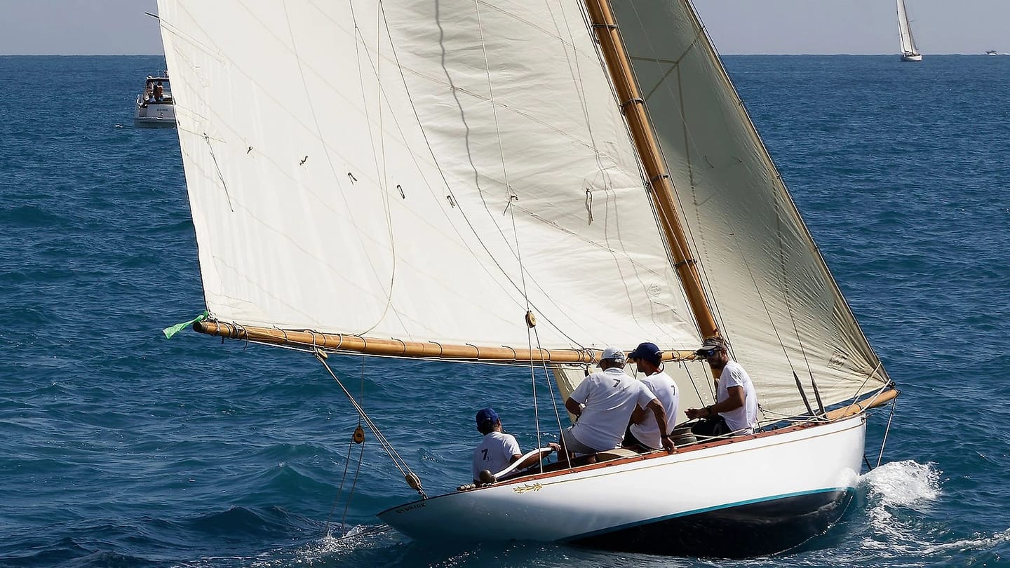 Sailboat carrying white sails on open water