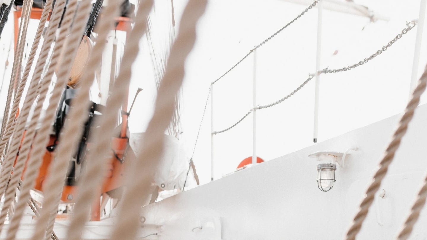 Sailor handling rigging on the deck of a vessel