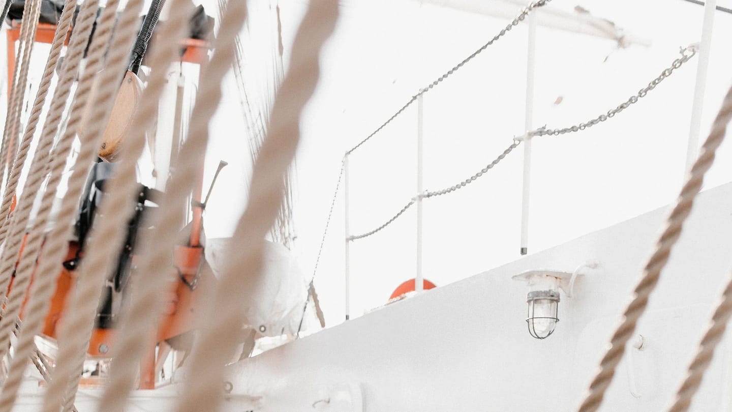 Sailor working with rigging aboard a tall vessel