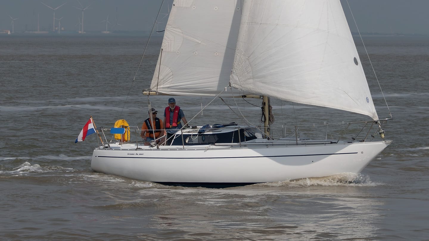 A sailing yacht seen broadside shows its sail plan above and immersed hull below.