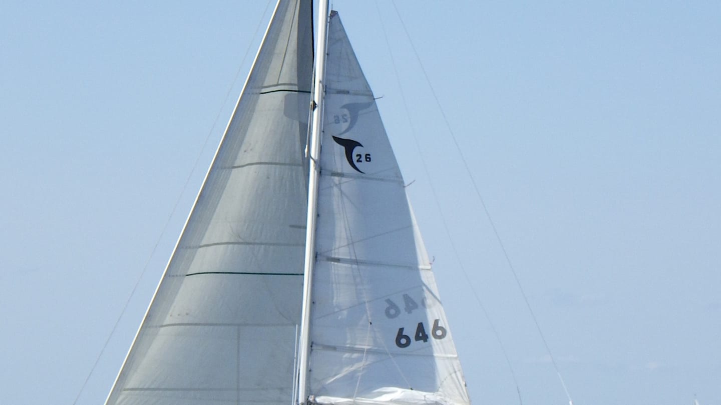 A reefed monohull sailing upright in open water