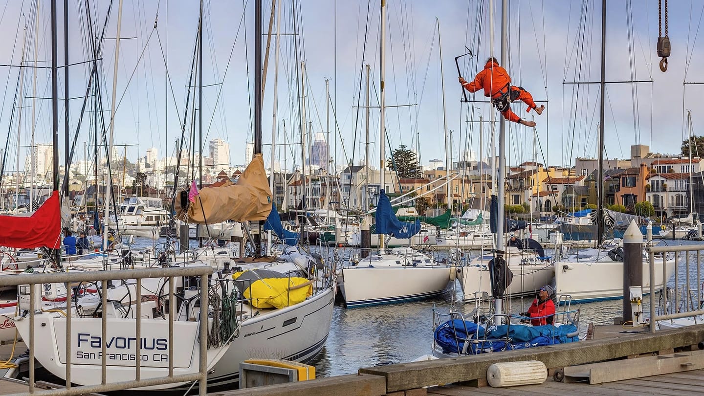 Worker inspecting a sailboat at a marina