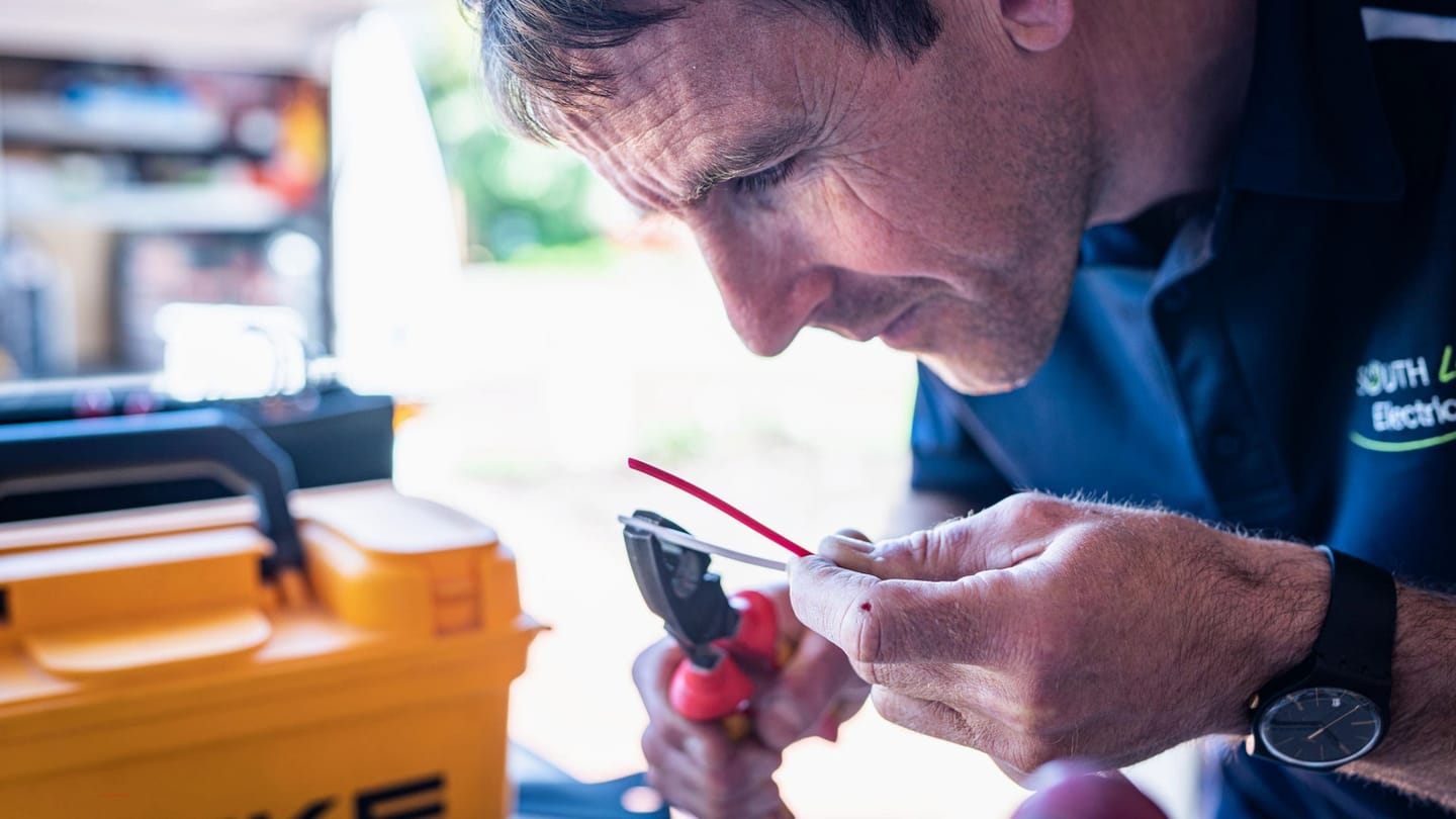 Technician checking cables and electrical connections with tools